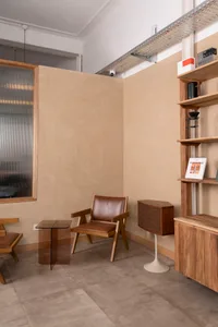 A modern living space with a dining table, couch, chairs, and bookshelf, creating a cozy atmosphere with a focus on functionality and comfort