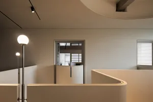 Empty white room with two doorways, one on each side, and a clean minimalist design