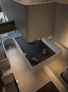 Open modern living area with a large white wall, rocks, and a clean minimalistic atmosphere