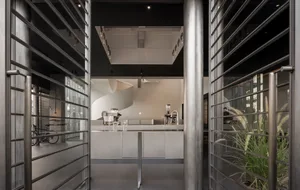 A clean and organized kitchen with two sinks, a refrigerator, microwave, and various kitchen items, set against a neutral background