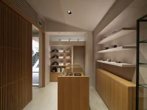 A clean and organized retail store with shelves displaying various garments, including jackets and dresses, in a well-maintained environment