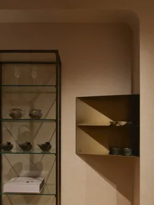 A well-lit room with a wooden bookshelf filled with decorative and functional items, creating a cozy and inviting atmosphere