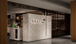 Modern restaurant interior with a marble wall, large window, and potted plants, featuring clean lines and minimalistic design elements