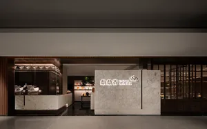 A modern Asian restaurant with a marble countertop, large window, and natural light, featuring potted plants, vases, and decorative elements