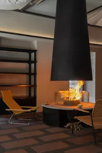 Cozy living area with a fireplace, two chairs, and a couch, surrounded by modern design elements