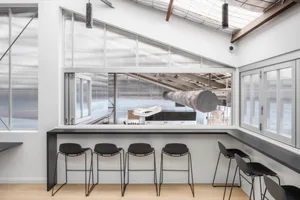 Open living area with a large window, four chairs, and ample natural light