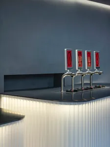 A simple bar area with two red drink dispensers on a marble countertop, creating a stylish and elegant atmosphere