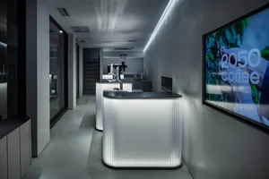 Empty restaurant kitchen with white walls and countertops, two sinks, a refrigerator, and a microwave, clean and well-organized