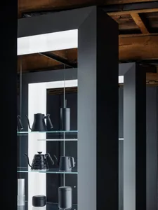 Elegant modern interior with black and white color scheme, glass shelf, and various vases in different sizes and shapes