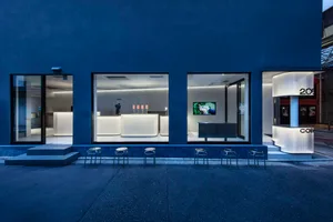 Empty modern restaurant with a large window, chairs, and a TV screen, featuring a clean and inviting atmosphere