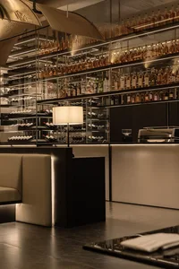 Elegant bar area with wine bottles, glasses, and cups on a countertop, creating a sophisticated atmosphere for enjoying a fine drink