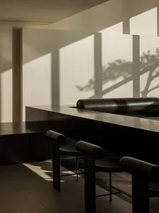 Empty modern dining space with a wooden table and four chairs, surrounded by a stylish interior design
