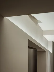 A dimly lit hallway with a white wall and two doors, creating a mysterious atmosphere