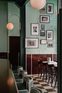 A modern restaurant interior with wooden walls and floors, featuring comfortable seating areas and dining tables
