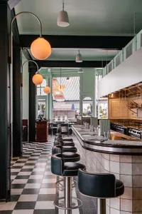 A restaurant interior with a bar, dining tables, and various seating options, creating an inviting and comfortable atmosphere for socializing and enjoying food and drinks