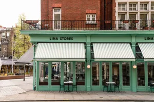 A casual storefront with outdoor seating area featuring chairs arranged around the exterior of the building, creating a welcoming atmosphere for customers