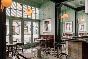 A well-lit restaurant interior with multiple tables and chairs, adorned with various items, creating a cozy atmosphere for patrons