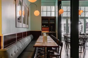 A restaurant dining area with multiple tables and chairs, creating a cozy and inviting atmosphere for guests