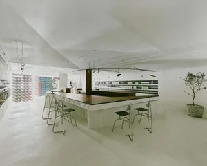 Empty restaurant with a long wooden bar counter, chairs, and a clean, well-organized atmosphere