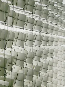 A minimalist arrangement of white boxes in various shapes and sizes mounted on a wall, creating a visually interesting display