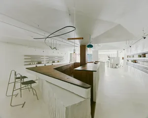 Open kitchen area with a bar counter, chairs, sink, and bottles, with a clean and well-organized atmosphere