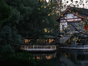 A yellow building near water with a staircase and outdoor seating area