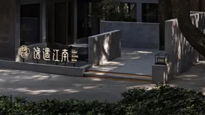 A modern Asian restaurant with a large stone wall, seating areas, potted plants, and a well-designed atmosphere