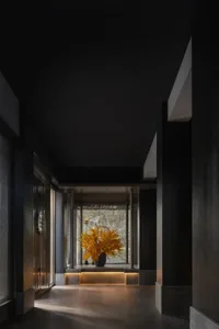 A well-lit room with a large window, two vases on a table, and a pleasant atmosphere