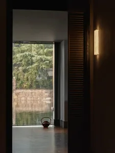 A dimly lit room with a view of water outside, featuring a bowl on the floor near the entrance