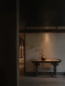 Cozy traditional room with a wooden table, potted plants, and dim lighting