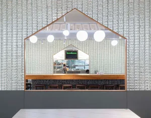 Modern restaurant bar with wood accents, TVs, and comfortable seating, well-lit for a welcoming atmosphere