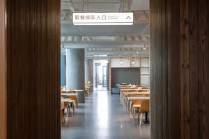 A clean and well-organized restaurant dining area with numerous wooden tables and chairs, ready for customers