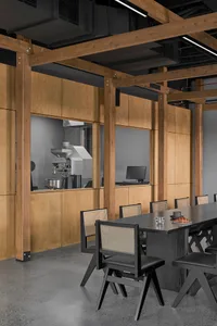 Warm and inviting restaurant interior with wooden walls and tables, featuring a large dining table and smaller tables throughout