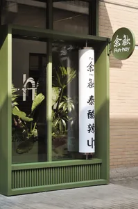 綠色牆面的小型商店，櫥窗展示各式盆栽植物，增添郁鬱蔥蔥的氛圍
