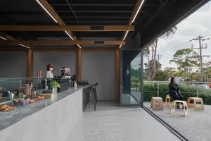 現代室內咖啡廳融入木質元素，設有桌椅的用餐區，以及顧客享用飲品的場景