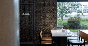 Dining table with two chairs in a restaurant setting, surrounded by marble and elegant decor