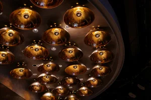 Ornate ceiling design featuring golden lights mounted on a silver surface, creating a visually striking pattern with an elegant and sophisticated atmosphere