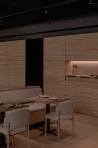 Empty restaurant interior with wooden walls and floors, featuring chairs and tables, a clean and well-organized atmosphere
