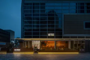 Warm and inviting restaurant with a wooden bar, dining tables, and chairs, illuminated by soft lighting