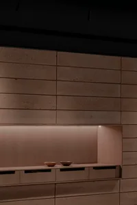 A kitchen with wooden cabinets and countertops, featuring two bowls on the countertop and warm lighting creating a cozy atmosphere