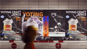 A room with several posters on the wall featuring different designs and sizes, including a political advertisement and artistic or cultural events