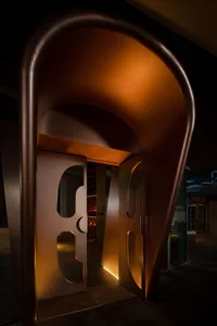 A doorway with a brown frame and golden design, set within a larger interior space