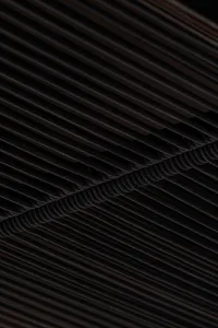 Dark industrial space with a black metal ceiling featuring multiple rows of ropes, creating a striking visual effect