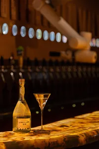 A relaxed bar lounge with comfortable seating, a dining table, and a wine glass, perfect for socializing and enjoying drinks