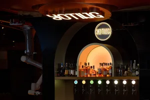 A well-stocked bar area with a variety of bottles displayed on the countertop, creating a casual and inviting atmosphere for patrons