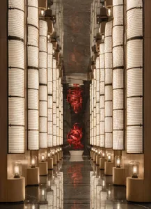 A museum-style hallway with white columns and red sculptures, creating a unique and visually appealing atmosphere