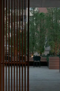 Cozy outdoor patio with a dining table and chairs, set for a meal with a candle, surrounded by evening atmosphere