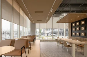 A modern restaurant interior with multiple dining tables and chairs, creating a comfortable atmosphere for guests