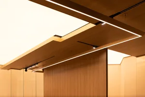 Dimly lit interior space with wooden walls and ceiling beams, creating a warm and inviting atmosphere