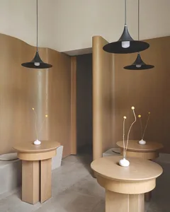 A well-lit interior design featuring two wooden tables with lamps, vases, and a warm atmosphere